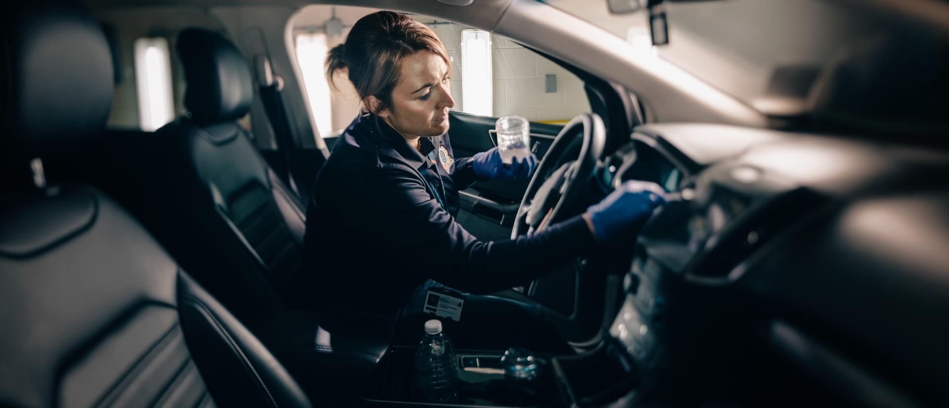 Civilian dusting for prints in car